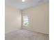 Neutral bedroom with carpet flooring, a window and electrical outlets visible at 12631 Chenwood Ave, Hudson, FL 34669