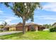 Charming single-story home with a well-maintained lawn, mature tree and a two-car garage at 12631 Chenwood Ave, Hudson, FL 34669