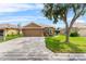 Beautiful single-story home with a two-car garage and a lush green lawn with a sidewalk at 12631 Chenwood Ave, Hudson, FL 34669