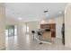 Spacious living area featuring tile floors, kitchen island with bar stools and outside views at 12631 Chenwood Ave, Hudson, FL 34669