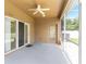 Covered patio featuring a ceiling fan, screen and exterior door for outdoor enjoyment at 12631 Chenwood Ave, Hudson, FL 34669