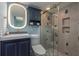 Modern bathroom features blue vanity, illuminated mirror, and a glass-enclosed shower at 1301 S Howard Ave # A9, Tampa, FL 33606