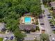 Overhead view of the neighborhood community pool surrounded by trees, lounge chairs, and apartment buildings at 13285 Arbor Pointe Cir # 202, Tampa, FL 33617