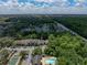 Aerial view of condo community showcasing a tennis court, community pool, ample parking and wooded surroundings at 13285 Arbor Pointe Cir # 202, Tampa, FL 33617