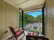 Enclosed balcony features two rocking chairs with red and white striped cushions overlooking the parking area at 13285 Arbor Pointe Cir # 202, Tampa, FL 33617