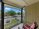 Enclosed balcony view features two rocking chairs with red and white striped cushions overlooking the street at 13285 Arbor Pointe Cir # 202, Tampa, FL 33617