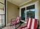 Enclosed balcony features two rocking chairs with red and white striped cushions near sliding glass doors at 13285 Arbor Pointe Cir # 202, Tampa, FL 33617