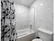 Bathroom features a tub with white marble-look tile surround and a black and white patterned shower curtain at 13285 Arbor Pointe Cir # 202, Tampa, FL 33617