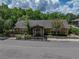Exterior view of the leasing center building with professional landscaping, mature trees, and a covered entryway at 13285 Arbor Pointe Cir # 202, Tampa, FL 33617