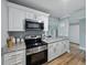 Bright kitchen with stainless appliances, granite counters, and white cabinets offers modern amenities at 13285 Arbor Pointe Cir # 202, Tampa, FL 33617