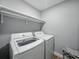 Modern laundry room featuring new front loading washer and dryer, with ample shelving at 13285 Arbor Pointe Cir # 202, Tampa, FL 33617