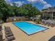 Large community pool area with lounge chairs and palm trees with apartment buildings in the background at 13285 Arbor Pointe Cir # 202, Tampa, FL 33617