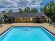 Community pool with blue water, stairs, and a clubhouse with lounge chairs surrounding the perimeter at 13285 Arbor Pointe Cir # 202, Tampa, FL 33617
