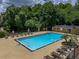 Community pool area with lounge chairs, palm trees, and a clubhouse in a neighborhood setting at 13285 Arbor Pointe Cir # 202, Tampa, FL 33617