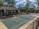 Aerial view of the community's tennis court with well-maintained surroundings, mature trees, and community buildings at 13285 Arbor Pointe Cir # 202, Tampa, FL 33617
