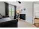 Bedroom featuring a sofa-bed, dark accent wall, window, and white door at 14135 Stowbridge Ave, Tampa, FL 33626