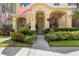 Close-up of home's inviting entrance and beautiful front garden with a sidewalk at 14135 Stowbridge Ave, Tampa, FL 33626