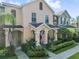 Charming two-story townhouse with manicured landscaping, American flags, and a welcoming front porch at 14135 Stowbridge Ave, Tampa, FL 33626