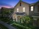 Charming two-story home with front yard featuring lush landscaping and an inviting porch during sunset at 14135 Stowbridge Ave, Tampa, FL 33626