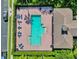 Aerial view of a rectangular pool area with lounge chairs, umbrellas, and a nearby building at 14135 Stowbridge Ave, Tampa, FL 33626