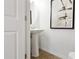 Powder room featuring a modern pedestal sink, tile flooring, and stylish artwork at 14135 Stowbridge Ave, Tampa, FL 33626