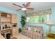A cozy bedroom features blue walls, ceiling fan, and desk space at 1441 S Hercules Ave, Clearwater, FL 33764