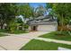 Charming two-story home featuring a well-manicured lawn, mature trees, and a welcoming front entrance at 14909 Oldgate Pl, Tampa, FL 33624