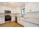 Well-lit kitchen featuring white cabinets, granite countertops, and stainless steel appliances at 14909 Oldgate Pl, Tampa, FL 33624