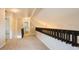 Upstairs hallway with carpeting, a dark railing, and views of the home's interior at 14909 Oldgate Pl, Tampa, FL 33624