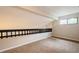 Carpeted loft area with railing and natural light coming from a window at 14909 Oldgate Pl, Tampa, FL 33624