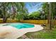 Backyard pool with ladder, stone bench and concrete patio surrounded by grass and fence at 14909 Oldgate Pl, Tampa, FL 33624