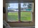 View of the landscaped backyard and waterfront through a large window at 1626 Sea Breeze Dr, Tarpon Springs, FL 34689
