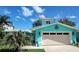 Charming turquoise home featuring a well-maintained lawn, two-car garage, and a lovely color scheme at 1626 Sea Breeze Dr, Tarpon Springs, FL 34689