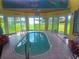 Bright and airy indoor pool with tile surround and backyard access, providing a private oasis at 1626 Sea Breeze Dr, Tarpon Springs, FL 34689