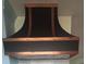 Close up of the black vent hood with custom bronze trim in the kitchen at 1626 Sea Breeze Dr, Tarpon Springs, FL 34689