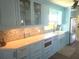 Custom cabinets in this kitchen feature glass fronts, modern hardware, and mosaic backsplash at 1626 Sea Breeze Dr, Tarpon Springs, FL 34689