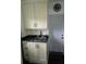 Laundry room featuring white cabinets, dark countertops, and access to the backyard at 1626 Sea Breeze Dr, Tarpon Springs, FL 34689