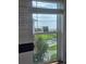 Window view with pool, water, palm trees, and tropical landscape at 1626 Sea Breeze Dr, Tarpon Springs, FL 34689