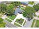 Stunning aerial view of the home with mature landscaping, an outdoor patio and long driveway at 1707 Solon Ave, Dunedin, FL 34698