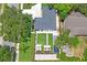 An aerial view of a home with a landscaped backyard, patio with firepit and lounge furniture at 1707 Solon Ave, Dunedin, FL 34698