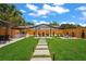 Expansive backyard showcasing lush green grass, a covered grilling area, and comfortable seating at 1707 Solon Ave, Dunedin, FL 34698
