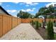 Backyard featuring a wooden fence with white stones, lush greenery and a swing set at 1707 Solon Ave, Dunedin, FL 34698