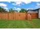 Backyard featuring a wooden fence with lush greenery and a compost storage area at 1707 Solon Ave, Dunedin, FL 34698