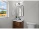A modern half bathroom offers a sleek sink and a large window to the property grounds at 1707 Solon Ave, Dunedin, FL 34698
