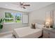 Comfortable bedroom featuring a ceiling fan, large window, a painting, and a bedside table at 1707 Solon Ave, Dunedin, FL 34698