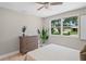 This bedroom features a three-drawer dresser, a window looking to the street, and plant decorations at 1707 Solon Ave, Dunedin, FL 34698