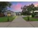 Beautifully landscaped single-story home with a unique stone accent wall and a long, inviting driveway at 1707 Solon Ave, Dunedin, FL 34698