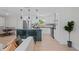 Open kitchen design with white cabinets, a dark island with bar stools, and stainless steel appliances at 1707 Solon Ave, Dunedin, FL 34698