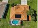 Aerial view of a home with a solar panel roof and screened pool surrounded by lush landscaping at 18168 Clearview Dr, Brooksville, FL 34604