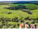 Picturesque aerial view of the property surrounded by vast green fields and mature trees, showcasing the landscape at 18168 Clearview Dr, Brooksville, FL 34604